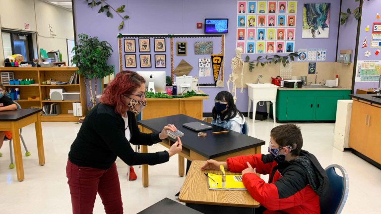 A teacher signs to a student