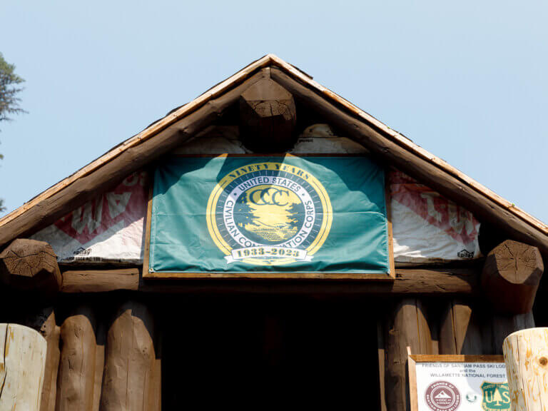 A Civilian Conservation Corps sign on the exterior of the Santiam Pass Ski Lodge